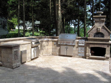Lakeside outdoor kitchen, grill, fireplace, and patio